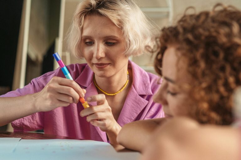 Two women engaged in a relaxed artistic activity, fostering creativity together indoors.